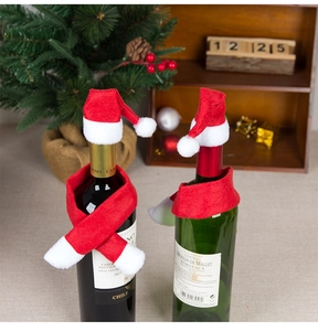 Close-up of festive Christmas wine bottle decor with mini Santa hat and red-white scarf