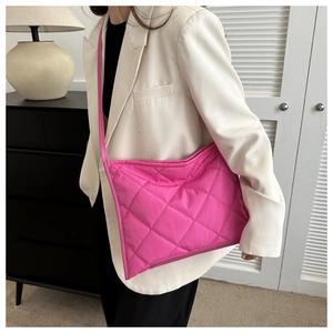 Detailed look at the rose pink quilted texture and durable nylon fabric of the crossbody bag