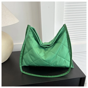Detail of green quilted rhombic pattern shoulder bag with a soft nylon texture