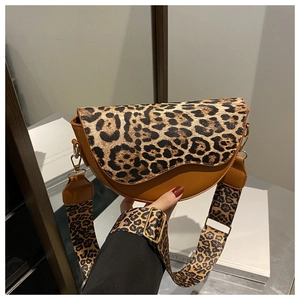 Detail of leopard print saddle bag featuring wide strap and golden metal buckle