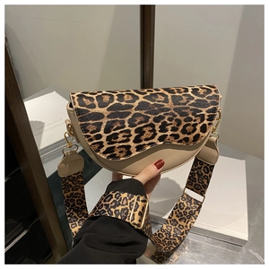 Close-up of beige saddle bag featuring leopard print wide strap and gold hardware