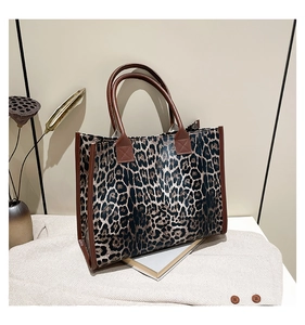 Detailansicht der Handtasche mit Leopardenmuster und braunen Griffen im Dekor