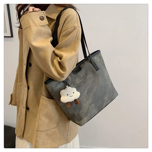 Grand sac cabas gris en daim avec un charm nuage mignon porté par un mannequin élégant