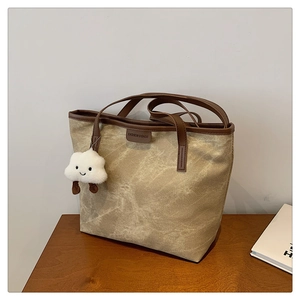 Détail du sac cabas beige vintage avec texture marbre et pendentif nuage doux