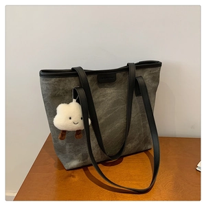 Détail d'un grand sac cabas vintage gris avec étiquette cuir et pendentif nuage doux