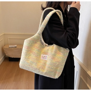 Detail of colorful plush tote bag with sozakka beauté woven label on black blazer