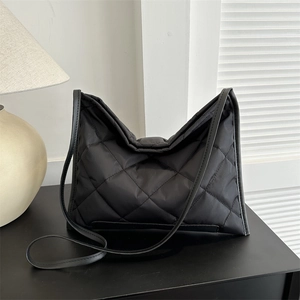 Fashionable black quilted puffer tote bag with glossy finish and versatile shoulder strap