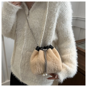 Detail der Plüsch-Beuteltasche mit silberner Kette und eleganten Perlenakzenten