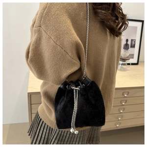 Detail der Plüsch-Eimertasche in Schwarz mit Silberkette und eleganten Perlenakzenten
