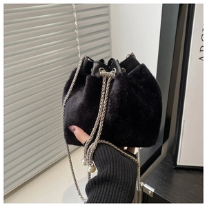 Detail der schwarzen Pelz-Eimertasche mit Silberkette und weißen Perlenanhängern