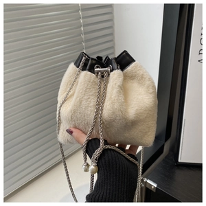 Detail einer Plüsch-Beuteltasche mit Perlenkette und silbernem Kordelzugverschluss
