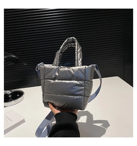 Détail du sac seau matelassé argenté avec bandoulière bleu clair et texture bouffante