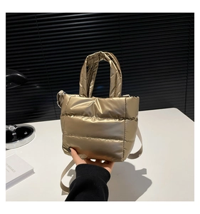 Détail du sac seau matelassé doré métallisé avec finition brillante et poignée