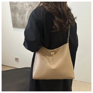 Close-up of khaki woven texture shoulder bag with gold metal buckle and chain strap