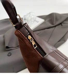 Close-up of the smooth metal zipper and premium suede stitching on dark brown tote bag