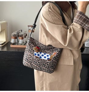 Vue latérale détaillée du sac à bandoulière léopard avec broderie de teckel dessin animé