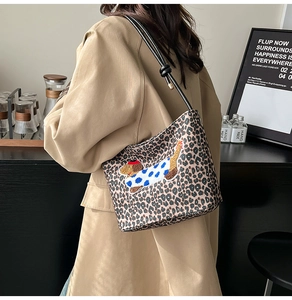 Détail du sac léopard avec broderie teckel et bandoulière en cuir à nœuds