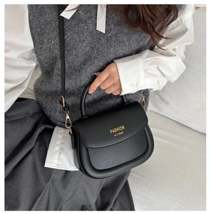 Détail d'un sac selle vintage noir avec finitions dorées et lettrage de mode