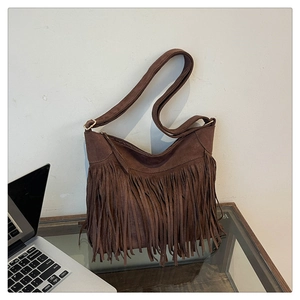 Close-up of retro bohemian dark brown suede crossbody bag with long decorative tassels