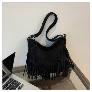 Detail of black suede tassel shoulder bag with gold buckle and layered fringe texture