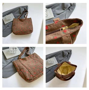 Detail view of large corduroy tote bag with strawberry print and zipper closure