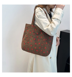 Detail of strawberry print on brown corduroy tote bag with large front pocket