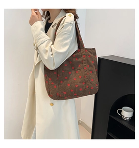 Brown corduroy tote bag with strawberry print shown on model for daily casual wear