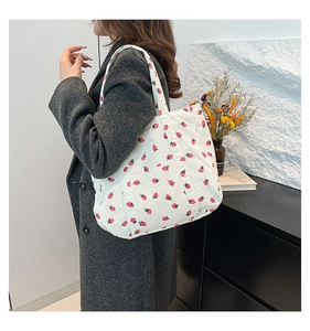 Detail view of large white corduroy strawberry tote bag with multiple front pockets