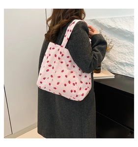 Detailed texture of pink corduroy tote bag with red strawberry print for daily use