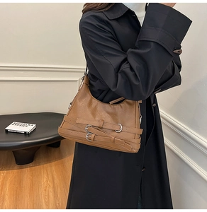 Dettaglio della borsa a mezzaluna marrone con trama in pelle vintage e fibbie in argento