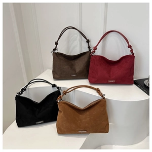 Macro view of four suede hobo bags in assorted colors with decorative knot handle details