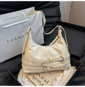 Dettaglio della borsa hobo crema con trama in pelle increspata e cinturini con fibbie