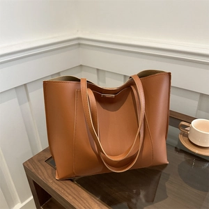 Minimalist caramel brown tote bag in premium faux leather with spacious interior and metal buckle