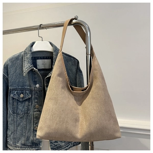 Détail de la texture du sac cabas en daim beige avec couture verticale minimaliste