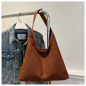 Détail du sac hobo en similicuir suédé marron avec une large bandoulière en cuir