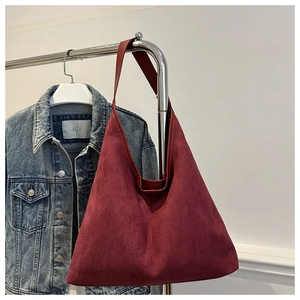 Détail d'un sac fourre-tout en daim bordeaux avec une texture vintage de haute qualité