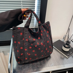 Large black corduroy tote bag with strawberry embroidery and a front pocket