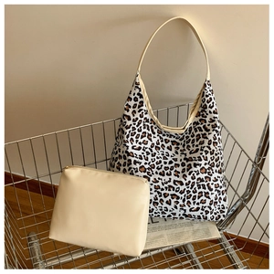 Detailed set of leopard print tote bag and solid cream clutch in a stylish metal cart