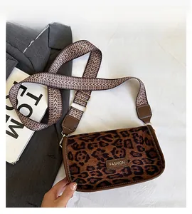 Detail of leopard print suede texture and golden Fashion metal logo on women's bag