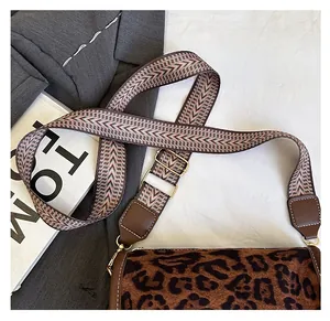 Detail of leopard print cylinder bag with woven strap on grey suit and magazine