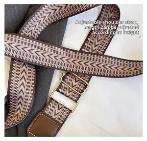 Adjustable woven shoulder strap with retro pattern and gold-tone metal hardware
