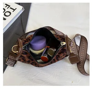 Detailed interior of leopard print crossbody bag showing spacious storage and makeup items