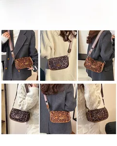 Detail of leopard print crossbody bag showing wide strap and fashion metal logo plate