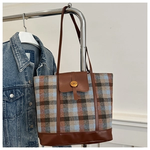 Detail of vintage plaid wool tote with brown leather strap and gold lettered buckle