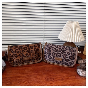Detail view of vintage leopard print crossbody bag with fashion tag and wide strap