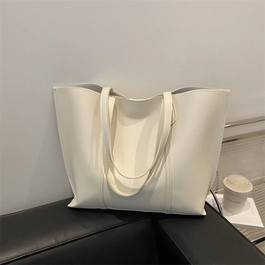 Minimalist beige faux leather tote bag with large capacity and sleek modern shoulder straps