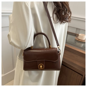 Détail du sac bandoulière rétro en cuir ciré avec fermoir rotatif en métal doré vintage