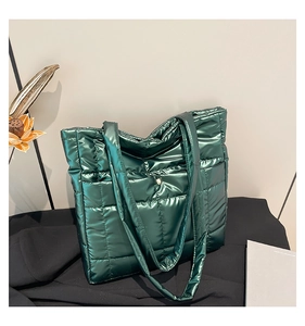 Detail of dark green quilted tote bag with metallic sheen and secure magnetic closure