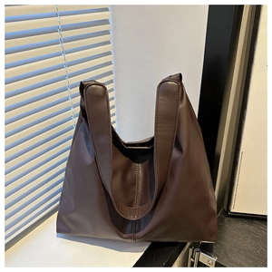 Detail of soft dark brown leather tote bag with elegant decorative central stitching