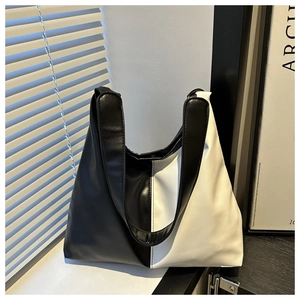 Detail of minimalist black and white contrast leather tote bag near a window